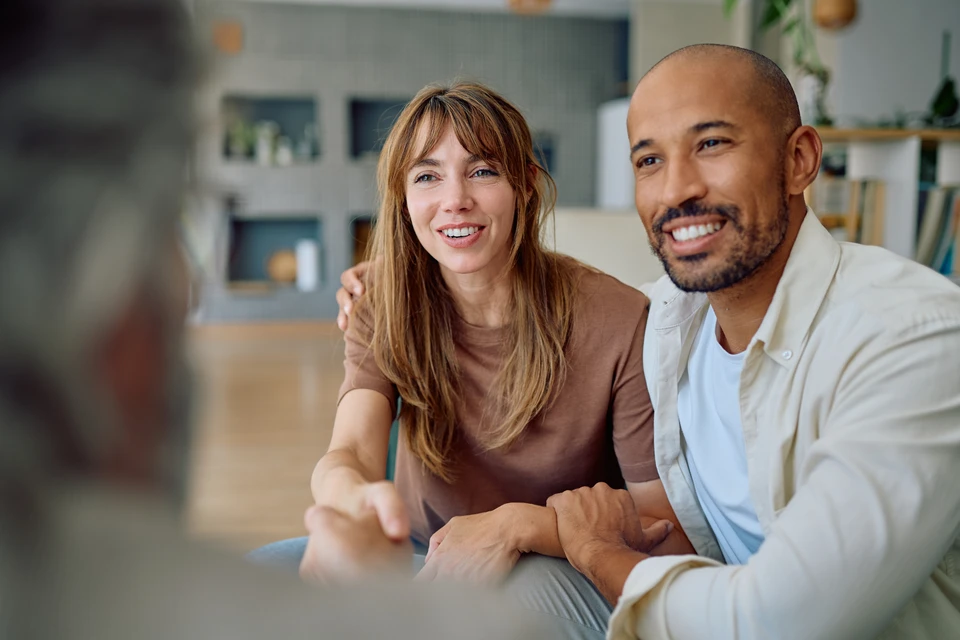 Agent d'assurance consultant un couple familial mature, discutant de l'assurance-maladie, signant un contrat de prêt hypothécaire de retraite à domicile, calculant les fonds, les investissements, l'épargne