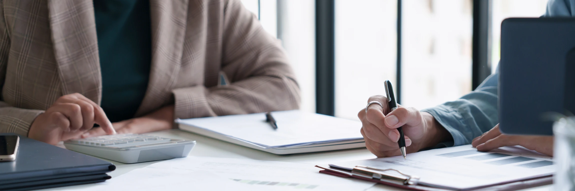 Réunion professionnelle dans bureau moderne avec conseiller financier en costume-cravate face à couple de clients seniors